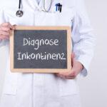 Arzt oder Urologe mit einer Tafel Diagnose Inkontinenz