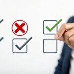 Hand setzt grünen Haken auf digitale Checkliste | Papierpolster
