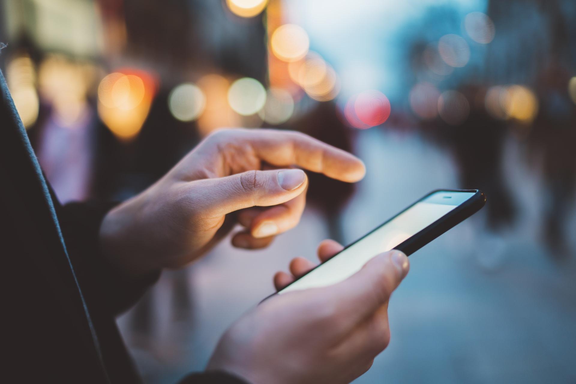 Hand bedient Smartphone im Stadtlicht | 187 Pods